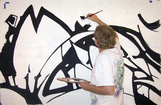 Art Deco inspired artwork by contemporary artist Nolan Haan, shown painting in his art studio